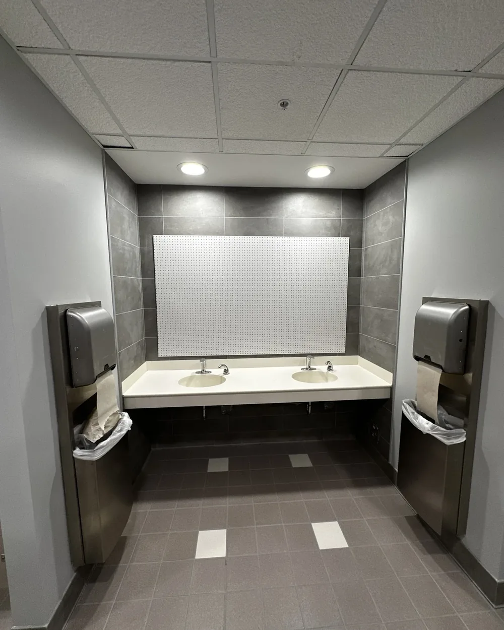 Finished restroom with double vanity and wall-mounted accessories